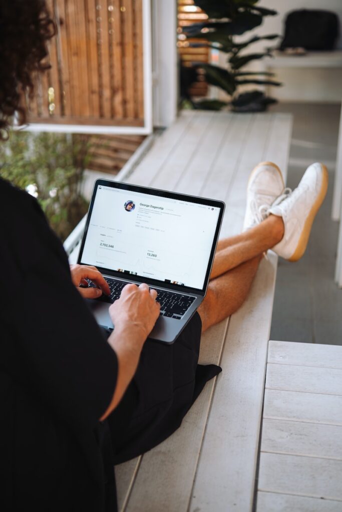 person sitting on a porch using a laptop