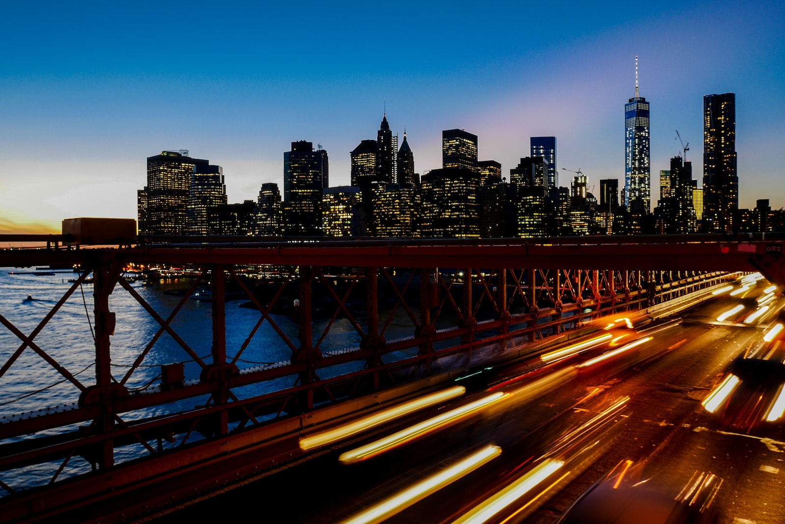 A long-exposure shot of light trails on the freeway with the New York city skyline at the back