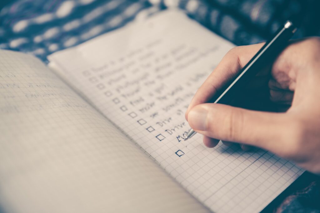 person writing list on book